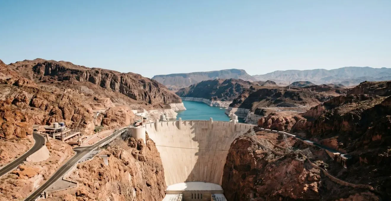 Aerial view of Hoover Dam with dramatic white bathtub ring visible on surrounding canyon walls showing declining water levels