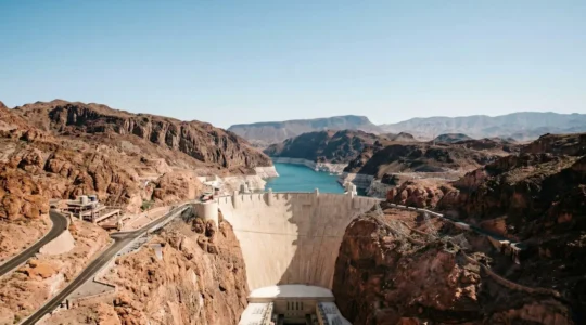 Aerial view of Hoover Dam with dramatic white bathtub ring visible on surrounding canyon walls showing declining water levels