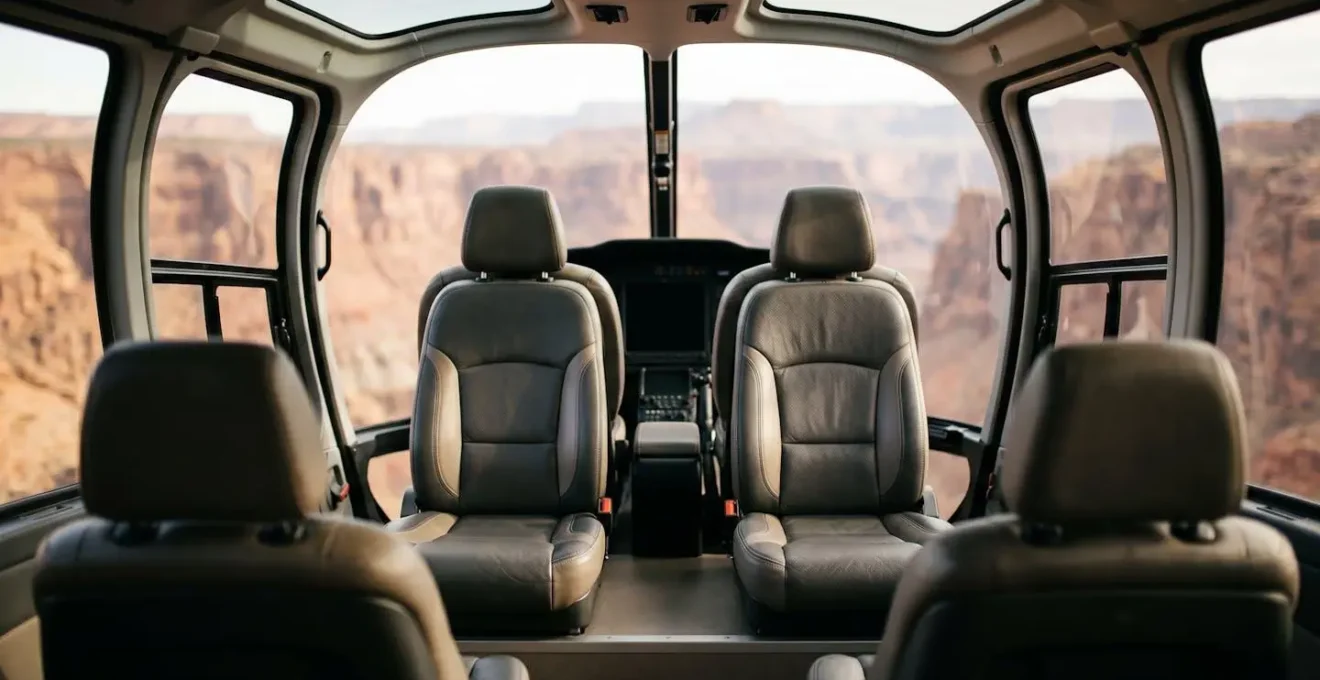 Interior view of a modern helicopter cabin featuring theater-style stadium seating with individual leather seats and expansive wraparound windows offering 180-degree views