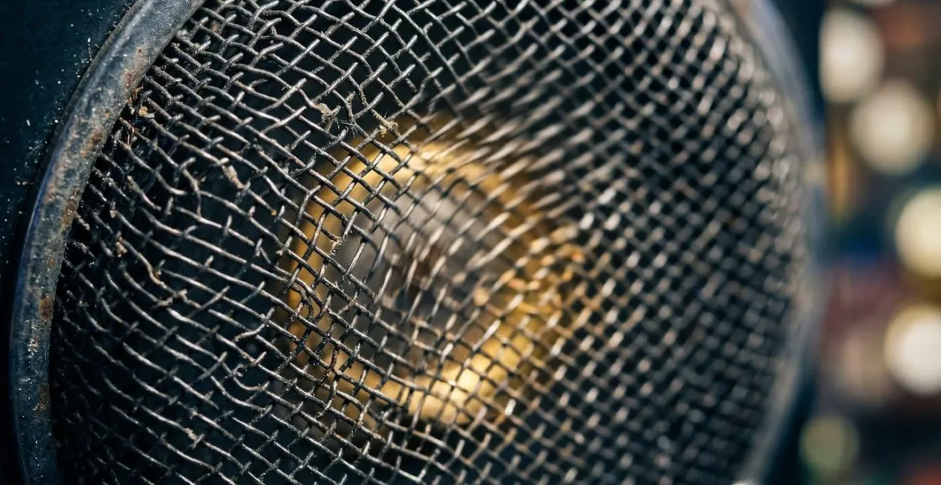 Extreme close-up of slot machine speaker grille with subtle vibration suggesting active sound emission