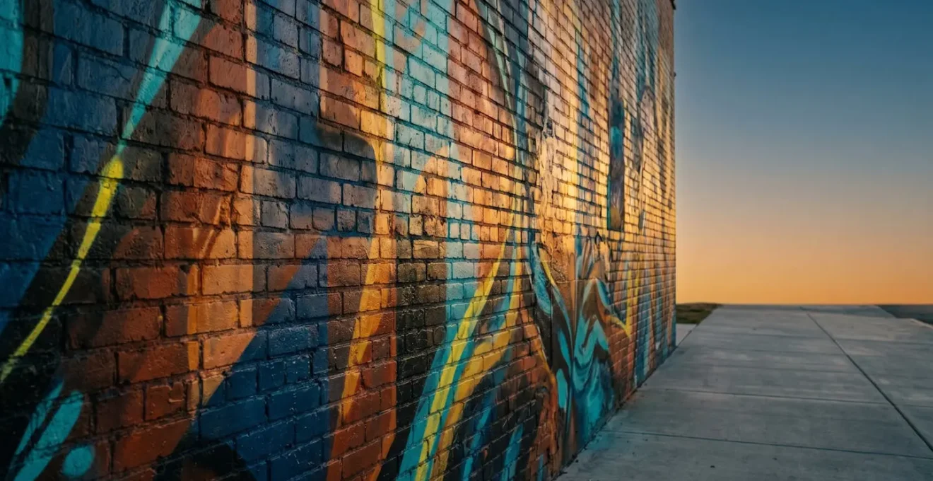 Dramatic side-angle view of street art mural during golden hour showing texture and light quality